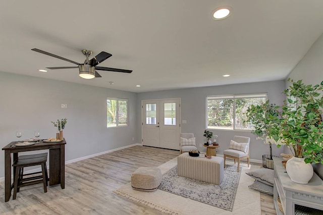 living room featuring ceiling fan, a wealth of natural light, and light hardwood / wood-style floors