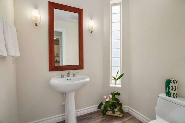 bathroom with toilet and hardwood / wood-style floors