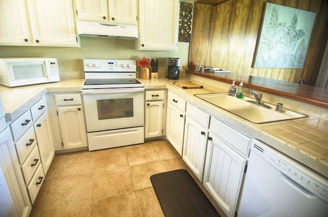 kitchen featuring white cabinets, light tile floors, exhaust hood, white appliances, and sink