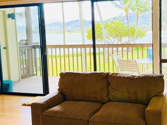 sunroom / solarium featuring a water and mountain view