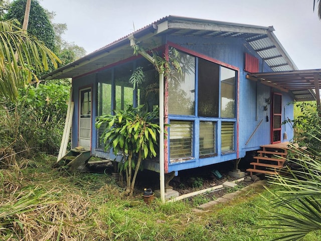 view of side of home featuring a sunroom