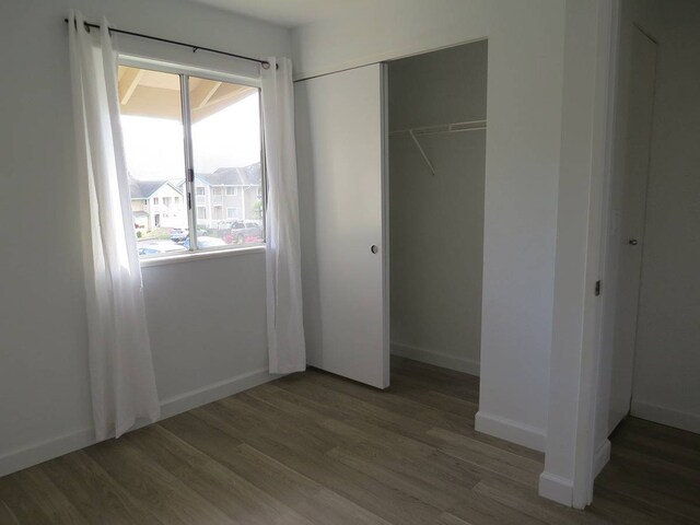 unfurnished bedroom featuring dark hardwood / wood-style flooring and a closet