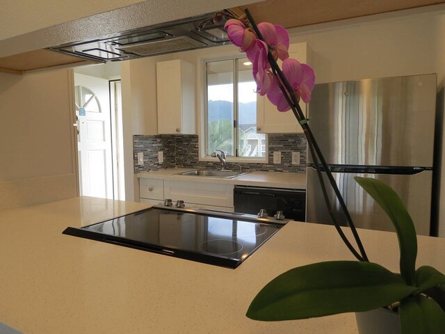 kitchen with sink, white cabinets, dishwasher, tasteful backsplash, and stainless steel refrigerator