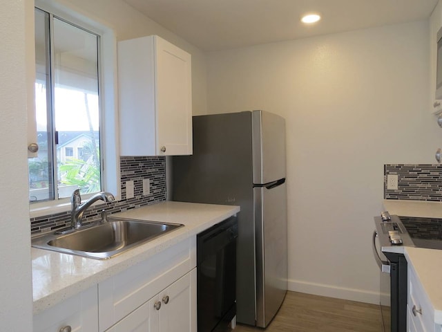 kitchen with white cabinets, sink, tasteful backsplash, and black dishwasher