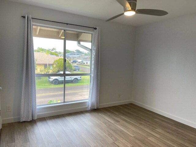 spare room with hardwood / wood-style floors and ceiling fan