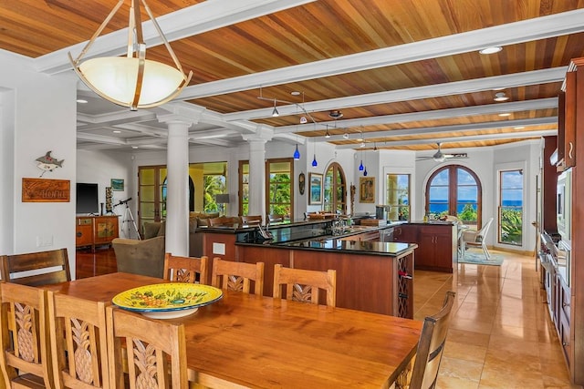 dining space featuring wooden ceiling, beamed ceiling, light tile floors, ceiling fan, and decorative columns