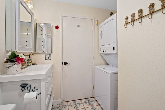 laundry area featuring sink, stacked washer / drying machine, and light tile floors