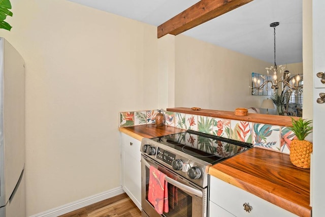 kitchen with light hardwood / wood-style floors, stainless steel electric range oven, white cabinetry, and a chandelier