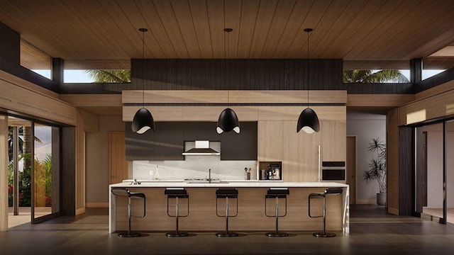 kitchen featuring decorative light fixtures, a healthy amount of sunlight, a kitchen bar, and stainless steel oven