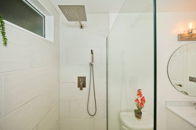 bathroom with toilet and a tile shower