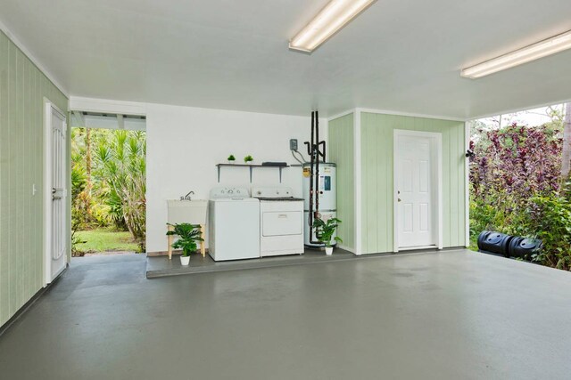 garage with electric water heater and independent washer and dryer