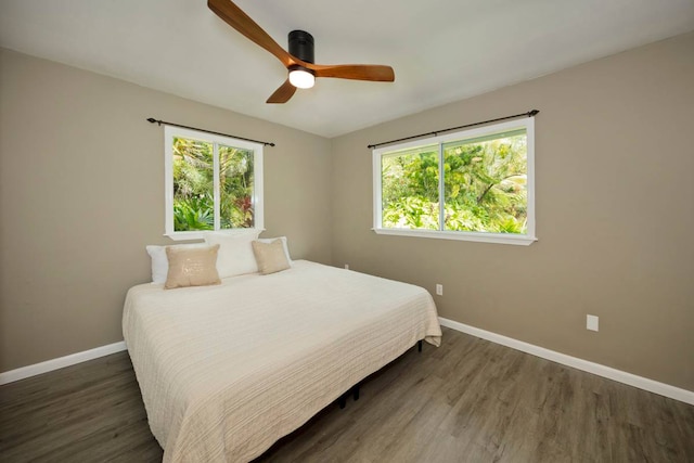 bedroom featuring multiple windows, ceiling fan, and dark hardwood / wood-style flooring