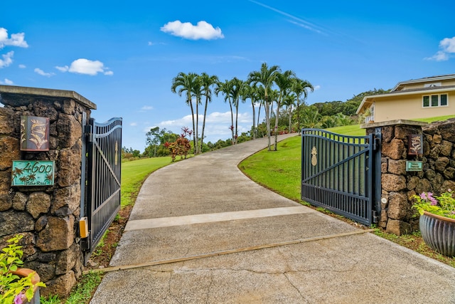 view of gate with a lawn