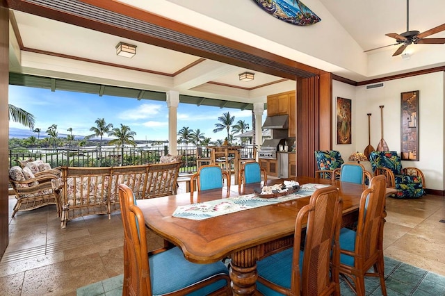 dining area with ceiling fan, lofted ceiling, and dark tile floors