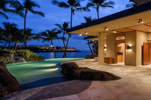 view of pool with a water view and a patio area