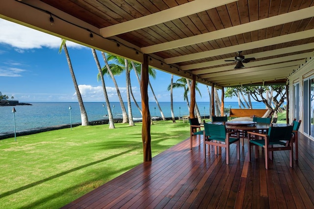 deck featuring a water view, ceiling fan, and a lawn