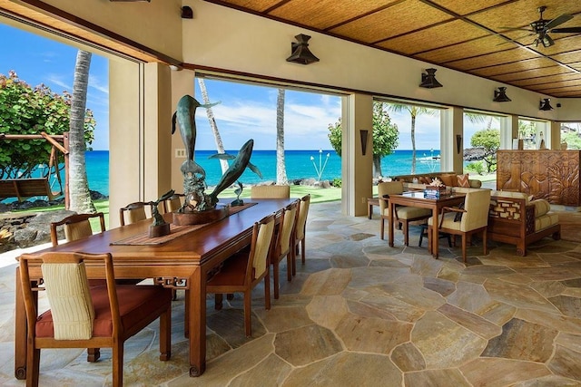 dining room with wooden ceiling, ceiling fan, and a water view