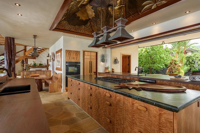 kitchen featuring a center island, sink, light tile floors, and stainless steel gas cooktop