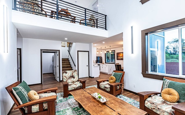 living room featuring dark wood-type flooring and a high ceiling