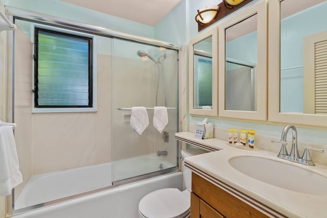 full bathroom with vanity, shower / bath combination with glass door, and toilet