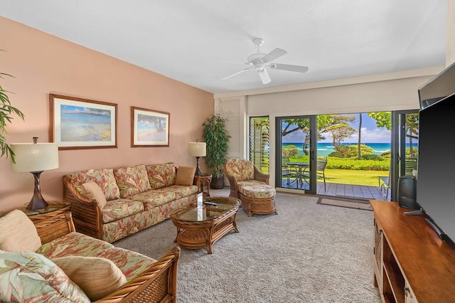 living room featuring a water view, carpet flooring, and ceiling fan