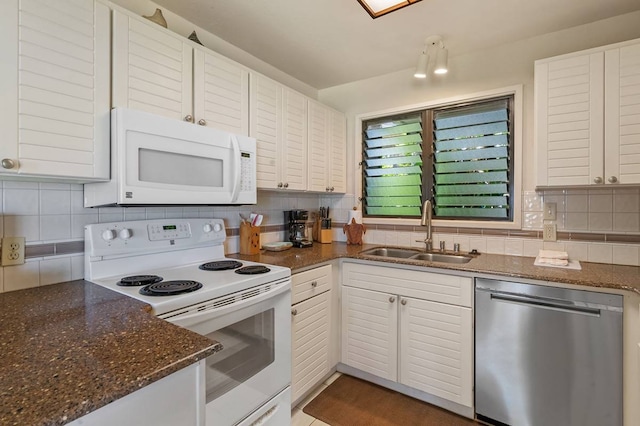 kitchen featuring tasteful backsplash, white appliances, dark stone countertops, and sink