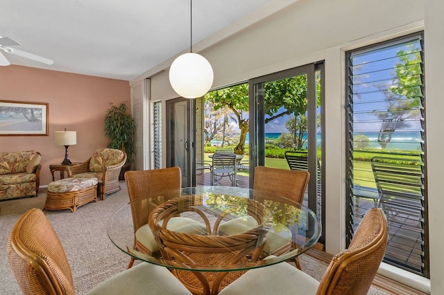 carpeted dining space with ceiling fan