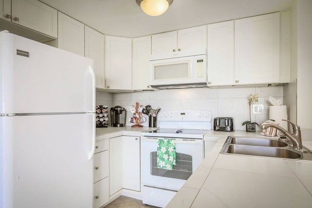 kitchen with white appliances, white cabinets, tile countertops, and sink