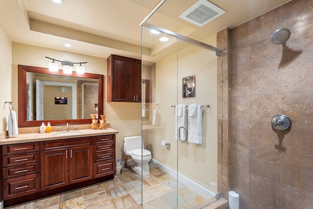 bathroom with vanity, a shower with shower door, and toilet