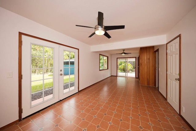 unfurnished room featuring dark tile floors, ceiling fan, and french doors