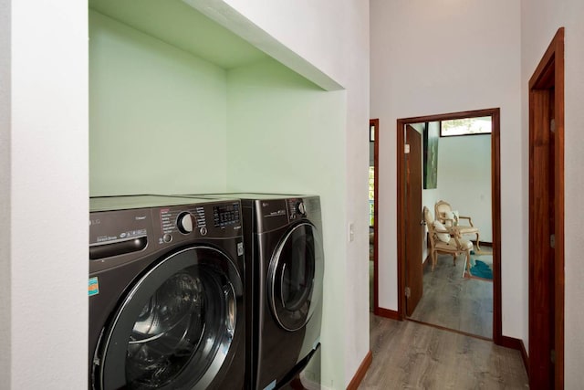 laundry area with hardwood / wood-style floors and washing machine and clothes dryer