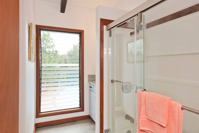 bathroom featuring enclosed tub / shower combo and vanity