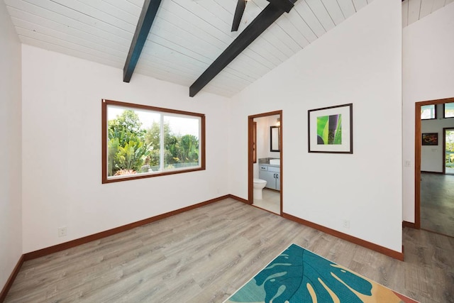 spare room with lofted ceiling with beams, light hardwood / wood-style floors, and ceiling fan