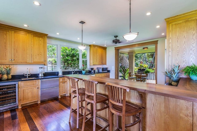 kitchen with dark hardwood / wood-style flooring, decorative light fixtures, sink, and beverage cooler