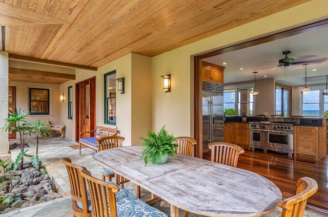 dining room featuring ceiling fan, wood ceiling, light hardwood / wood-style flooring, and a healthy amount of sunlight