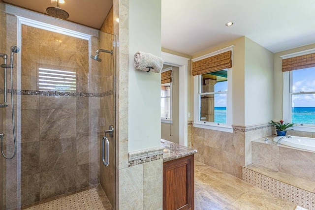 bathroom with tile floors, a water view, and separate shower and tub