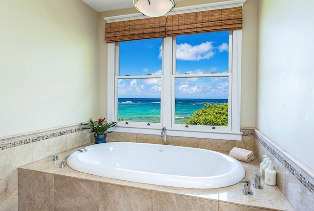 bathroom with a water view and a relaxing tiled bath