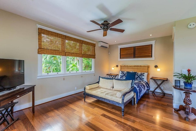 bedroom with a wall mounted air conditioner, ceiling fan, and hardwood / wood-style flooring