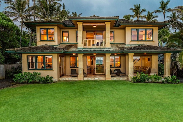 back of house with a yard, a balcony, and a patio