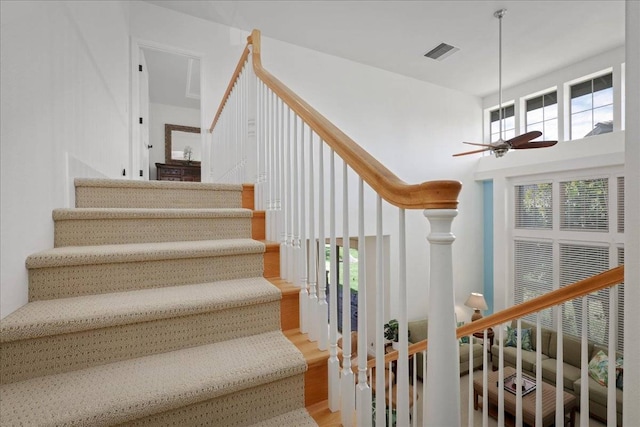 stairs featuring light hardwood / wood-style floors and ceiling fan