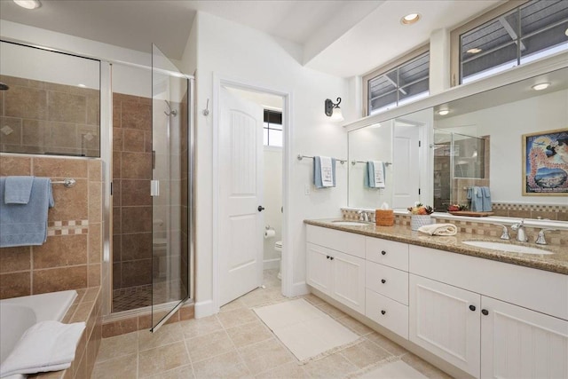 full bathroom with toilet, double vanity, tile floors, and independent shower and bath