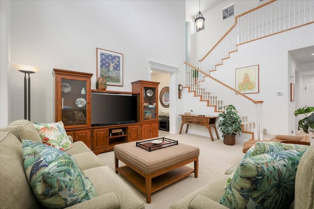 carpeted living room featuring a towering ceiling