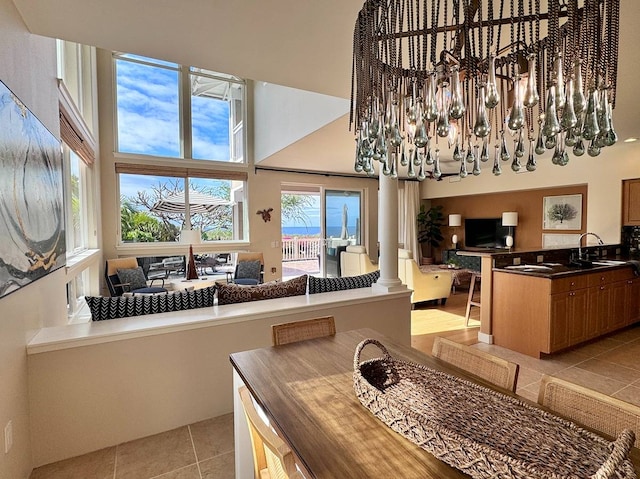 tiled dining space with a towering ceiling, sink, and ornate columns