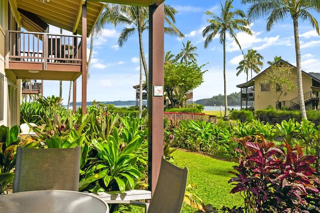 view of yard with a balcony and a water view