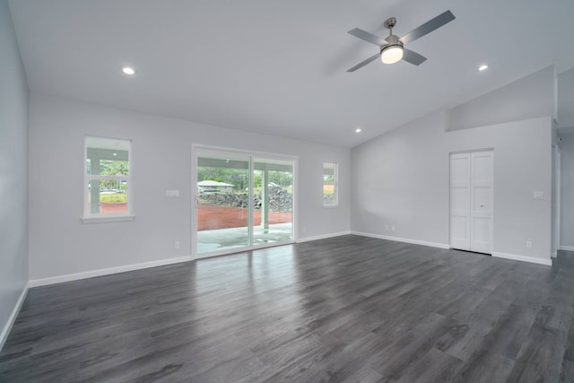 empty room with high vaulted ceiling, ceiling fan, dark hardwood / wood-style floors, and a wealth of natural light