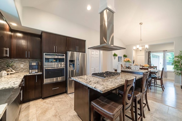 kitchen featuring a chandelier, stainless steel appliances, light stone countertops, island exhaust hood, and light wood-type flooring