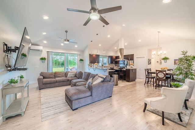 living room featuring light hardwood / wood-style floors, ceiling fan with notable chandelier, and vaulted ceiling