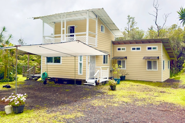 back of property featuring a balcony