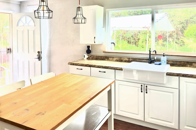 kitchen with plenty of natural light, wood counters, dark wood-type flooring, and white cabinets