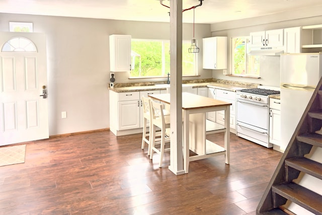 kitchen featuring white appliances, dark hardwood / wood-style floors, extractor fan, white cabinets, and pendant lighting